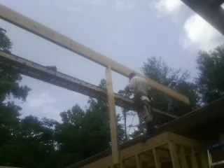Carpenter setting a ridge beam over a new addition frame — Ice Dam Removal by Roofing Brothers in Hungry Horse