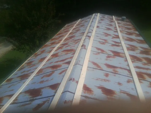 Rusted metal roof panels with new wood purlins before replacement — Storm Damage Roof Repair in Hungry Horse by Roofing Brothers