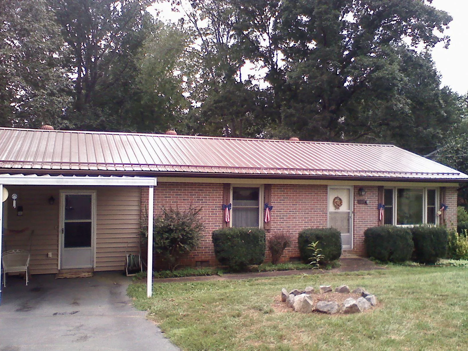 Bronze metal roof and carport on a brick ranch home — Roof Repair work by our crew in Hungry Horse